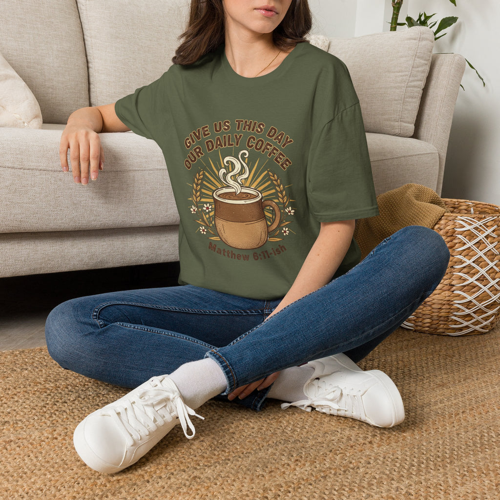 T-shirt featuring “Give Us This Day Our Daily Coffee”, coffee detail and bold lettering; resilient faith.