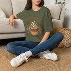 T-shirt featuring “Give Us This Day Our Daily Coffee”, coffee detail and bold lettering; resilient faith.