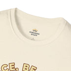T-shirt featuring “Peace, Be Still”, sunrise detail and coffee detail and vintage lettering; strong conviction.