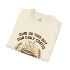 T-shirt featuring “Give Us This Day Our Daily Coffee”, coffee detail and bold lettering; hopeful spirit.