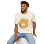 T-shirt featuring “Peace, Be Still”, sunrise detail and coffee detail and vintage lettering; peaceful assurance.